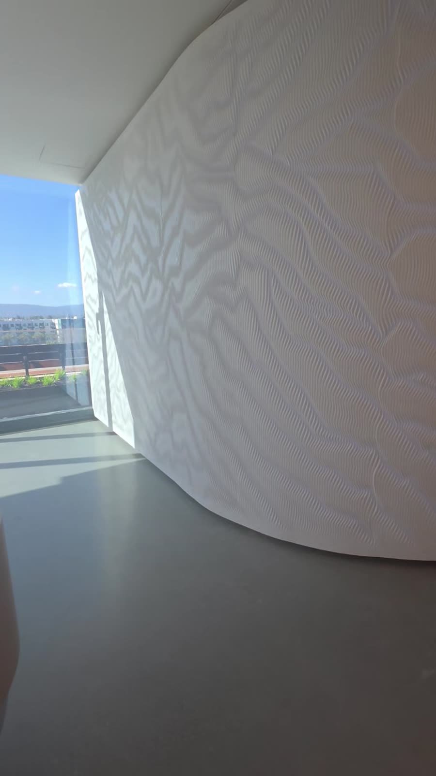 Curved white carved feature wall in sunlight