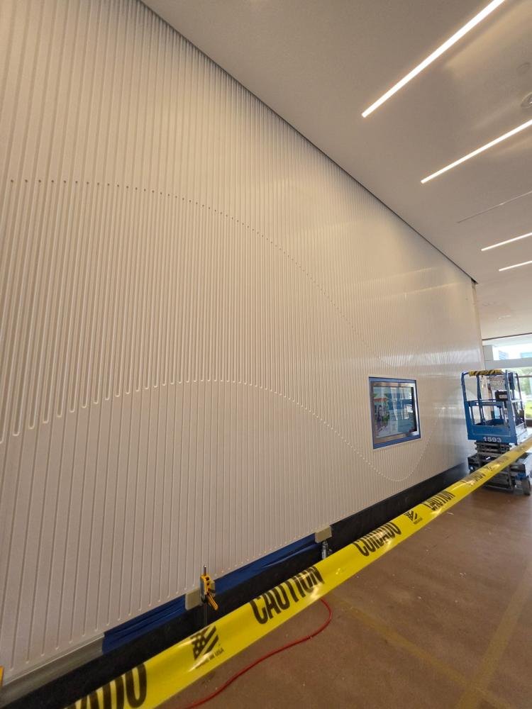Full-height carved fluted wall with a wave pattern in a commercial lobby